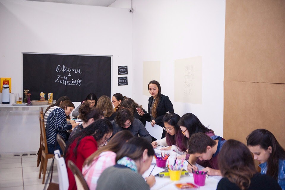 Oficina presencial de lettering com a artista ensinando